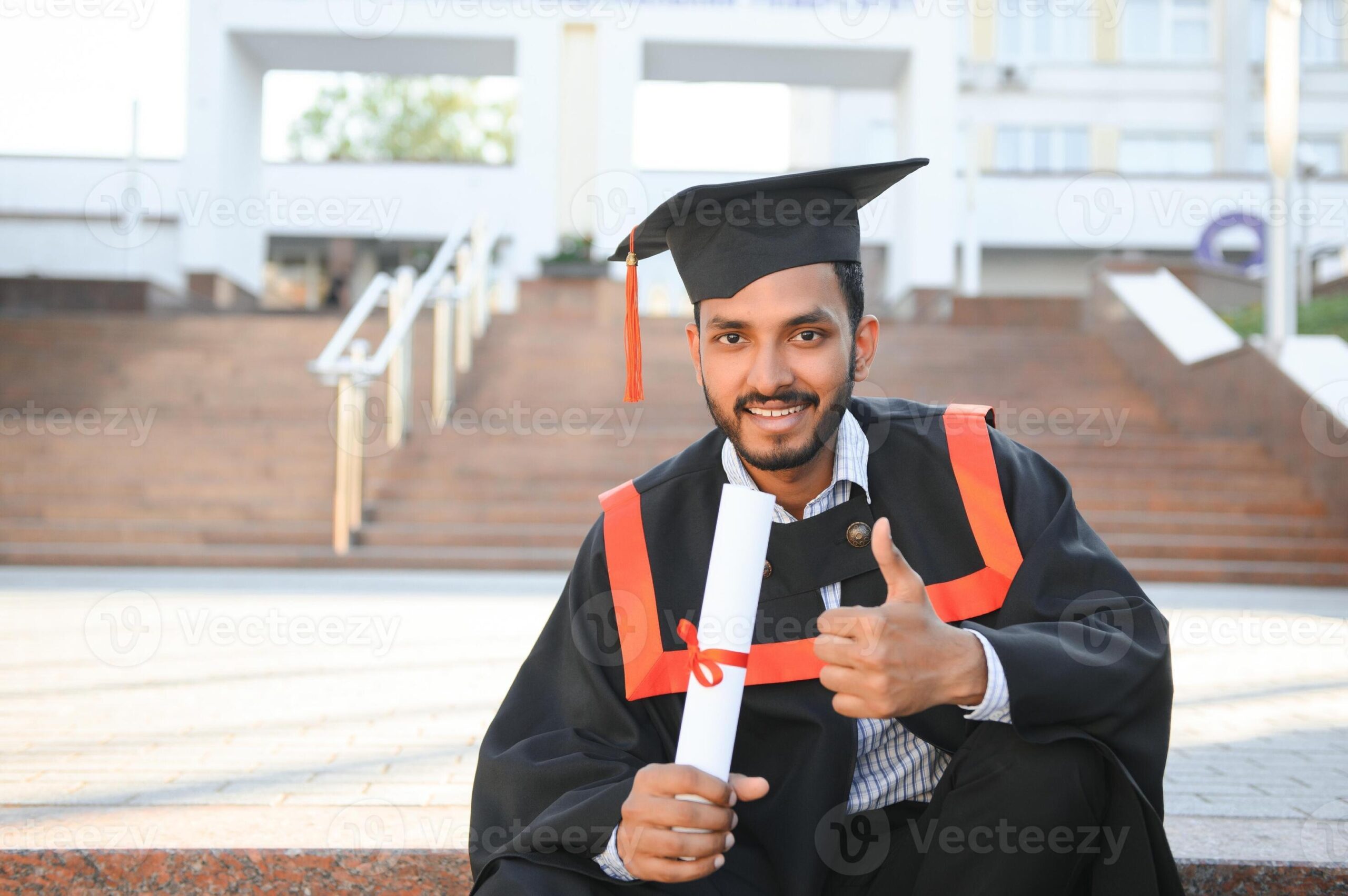 young-indian-graduated-boy-holding-his-graduation-degree-convocation-ceremony-student-graduate-posing-photo